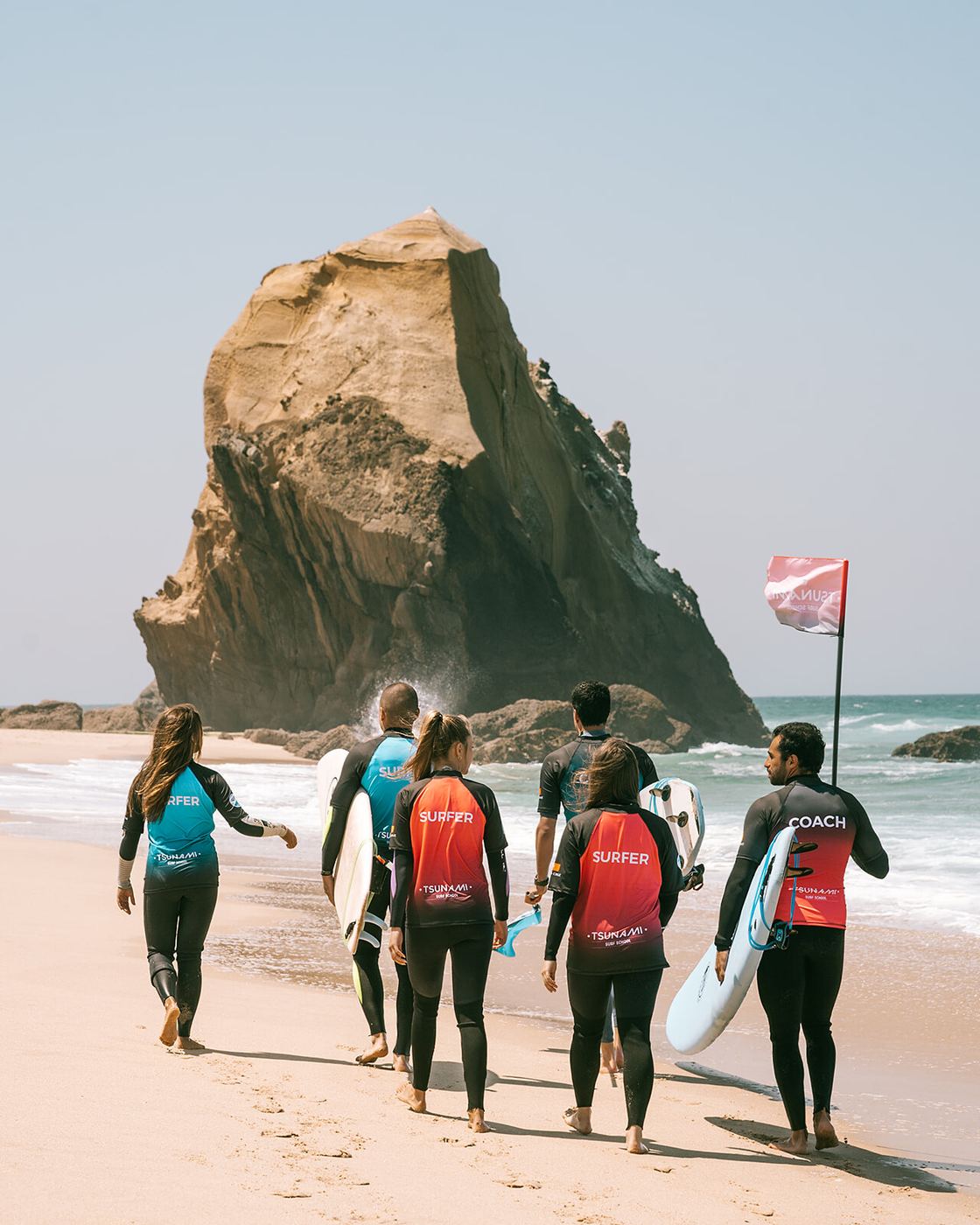 A Tsunami group walking down the beach towards the rock at Santa Cruz