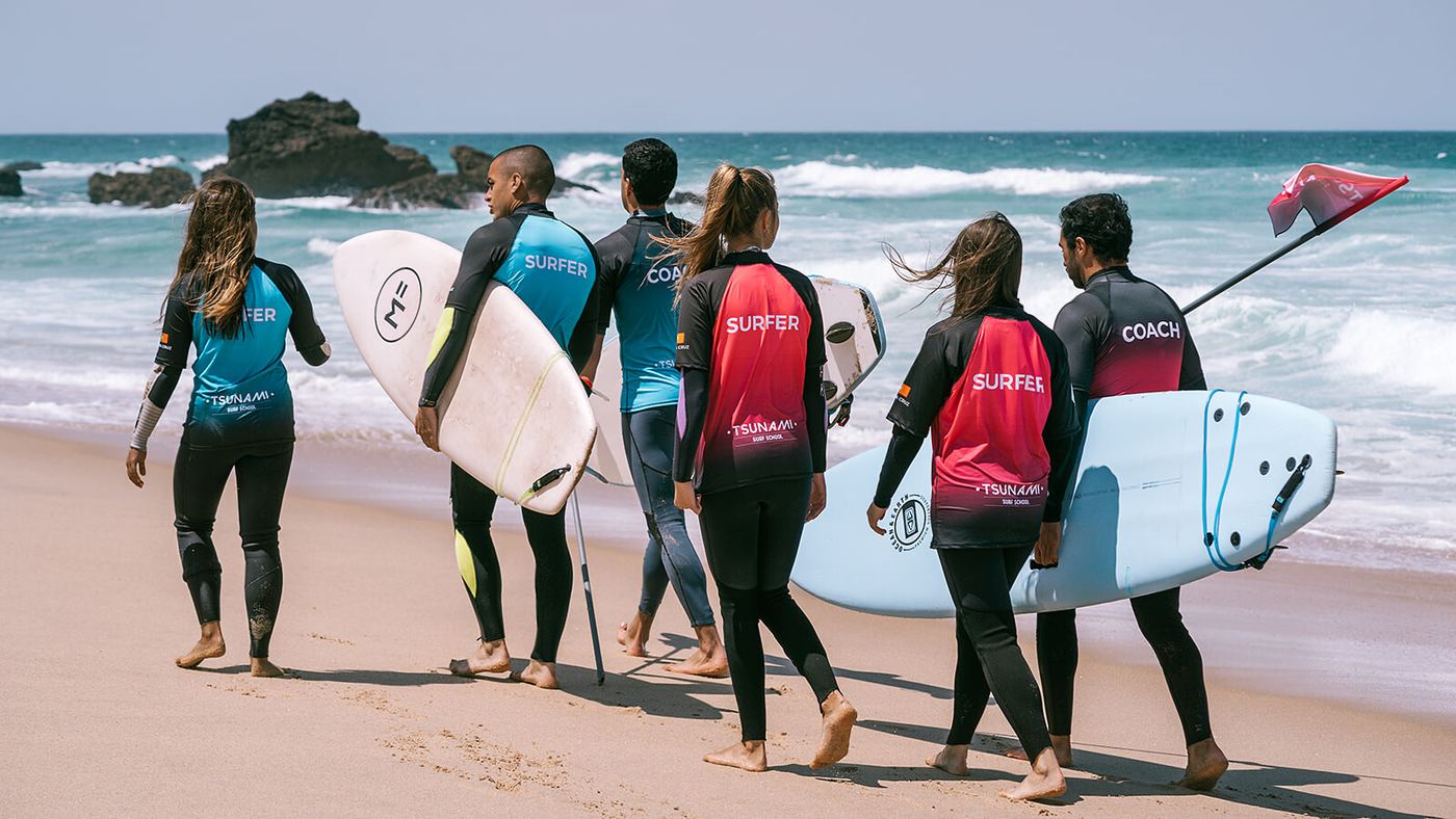 A group carrying boards down to the water