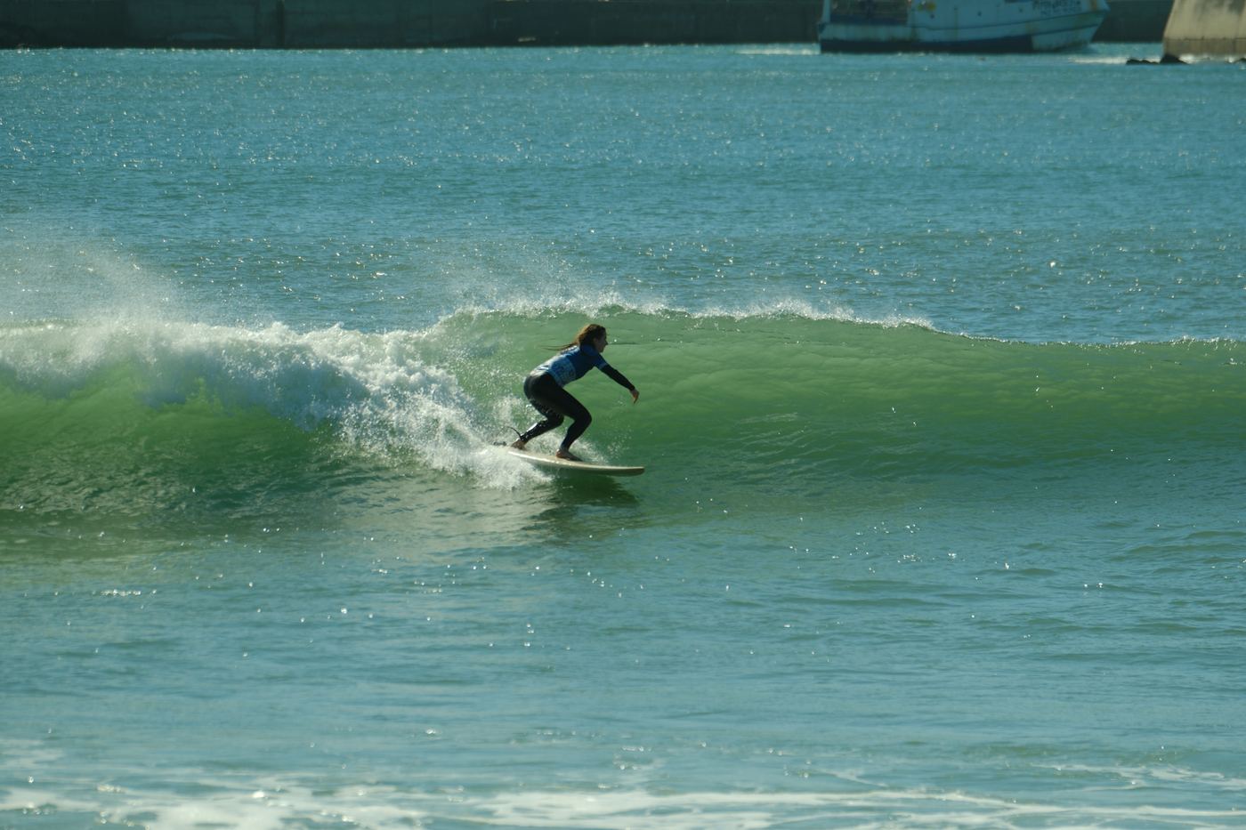 A surfer on a clean green wave off the peninsula