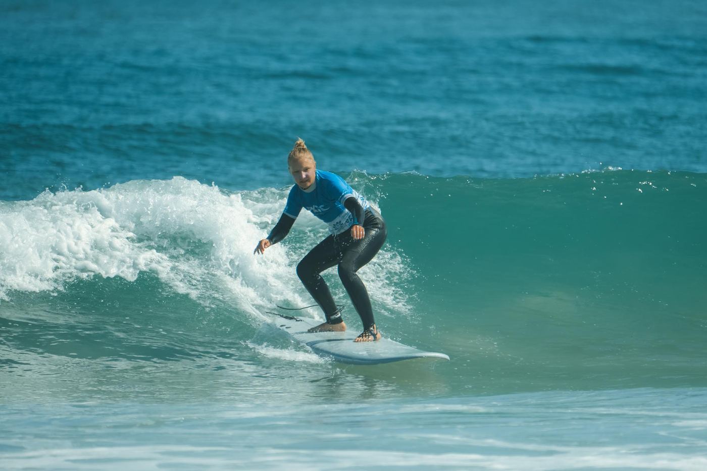 A surfer riding across the face of a wave