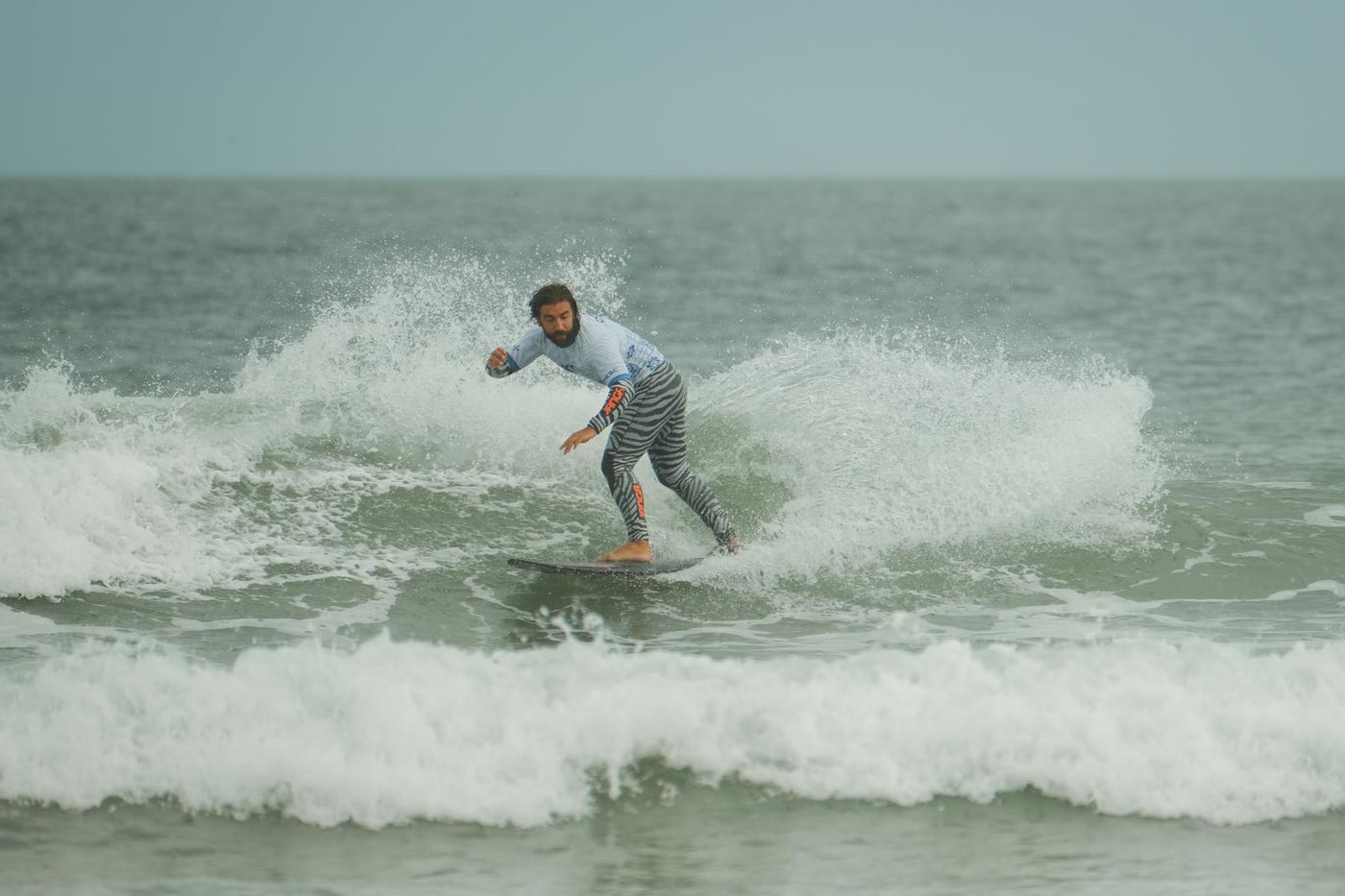 A surfer driving through the whitewater