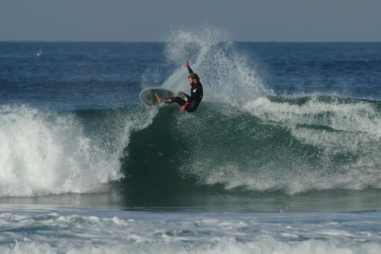 A surfer turning off the top of a wave at Areia Branca