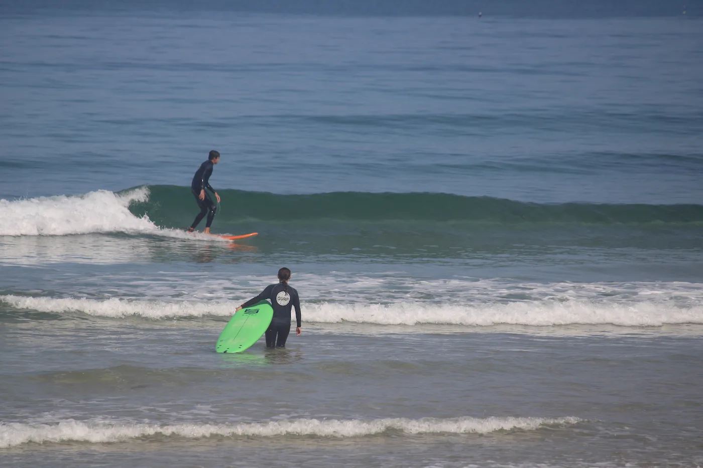 A surfer riding past on a long wall of water