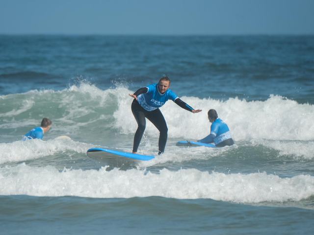 A PKSC coach pushing a student into a wave