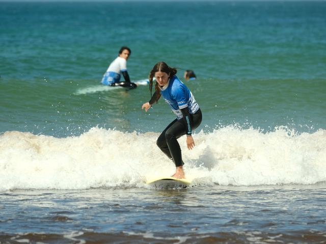 Two surfers in the whitewater, one already standing
