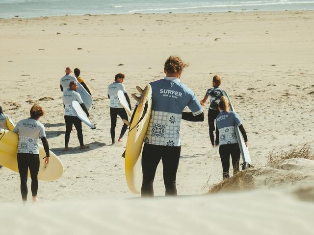 A PKSC group walking down the dune to the water with their boards