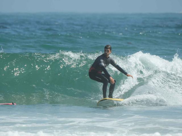 A surfer turning on a green wave off the peninsula