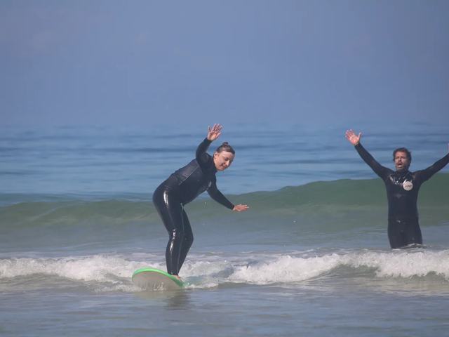 A coach throwing his arms up as a student rides past him