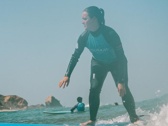 A Tsunami coach pushing a student into a wave