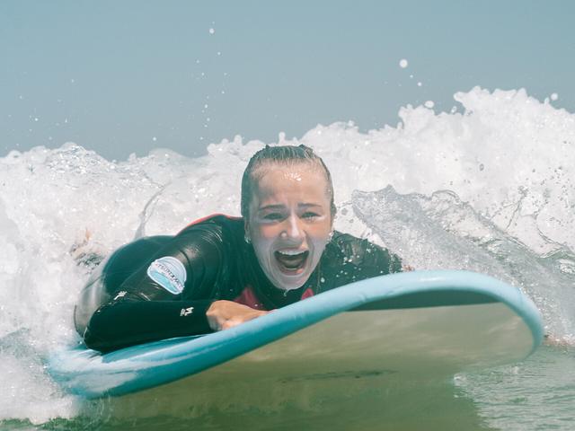 A student grinning after catching a wave